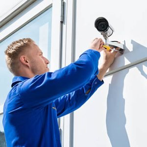 Technician Fixing Camera On Wall With Screwdriver Technician Fixing Camera On Wall With Screwdriver